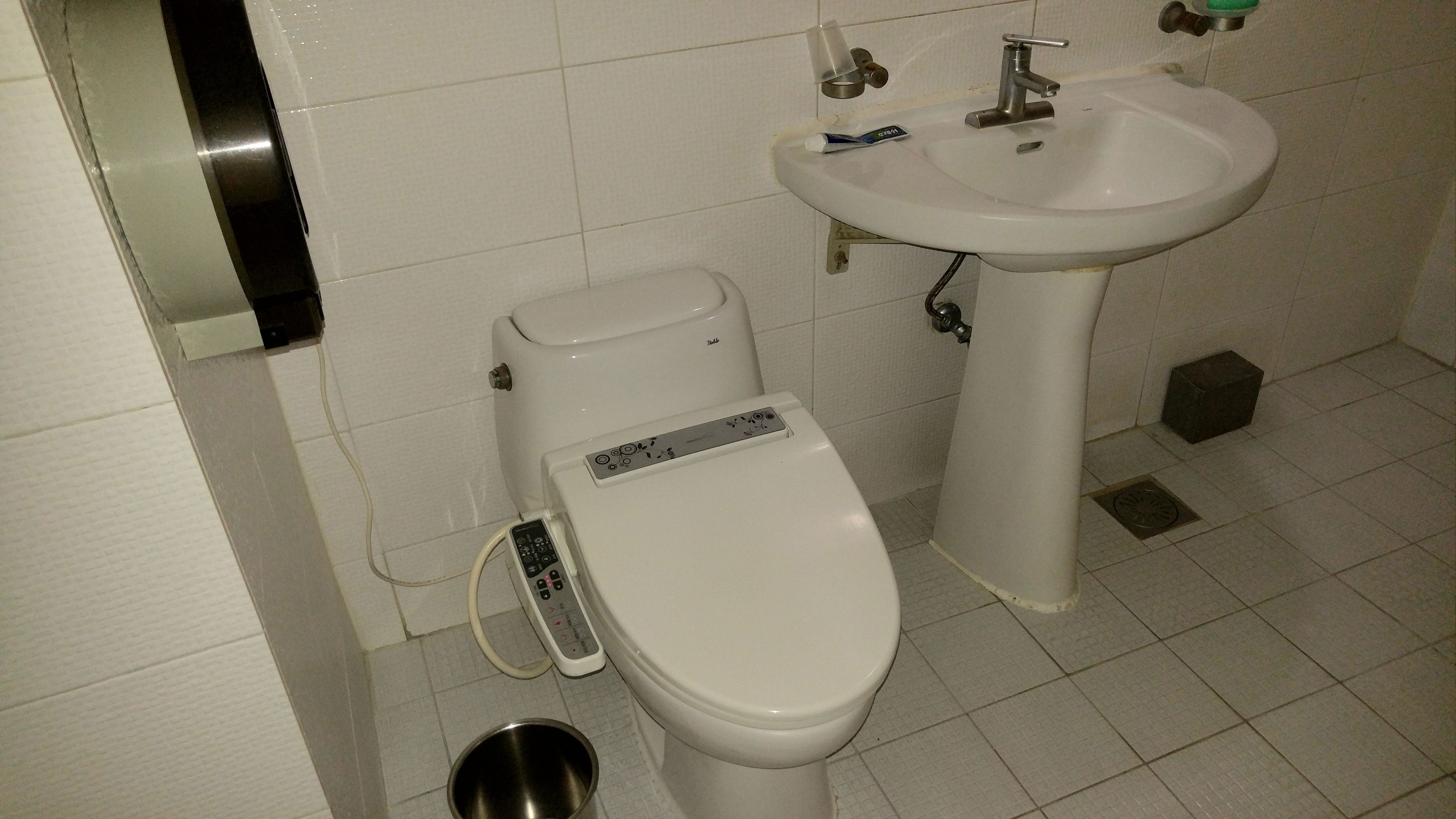 Um banheiro com vaso sanitário, pia e bidê.