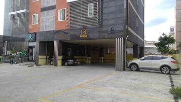 L’entrée d’un parking, avec une enseigne d’hôtel et un panneau indiquant qu’il s’agit d’un parking, situés au-dessus.