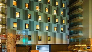 A modern hotel with a grid of uniformly lit windows, a flat facade, and a central entrance. - Hotel Resol Akihabara (Tokyo)
