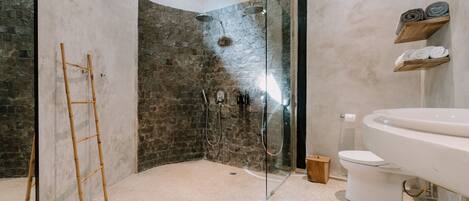 A modern bathroom with a glass-enclosed shower, a white toilet, and a large mirror.