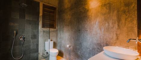 A bathroom with a shower, toilet, and sink.