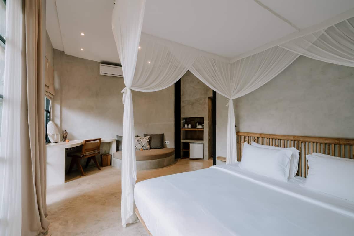 Une chambre avec un grand lit, un bureau et un coin salon.