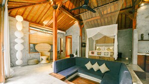 Un intérieur moderne avec un canapé bleu, un plancher en bois et un ventilateur de plafond.