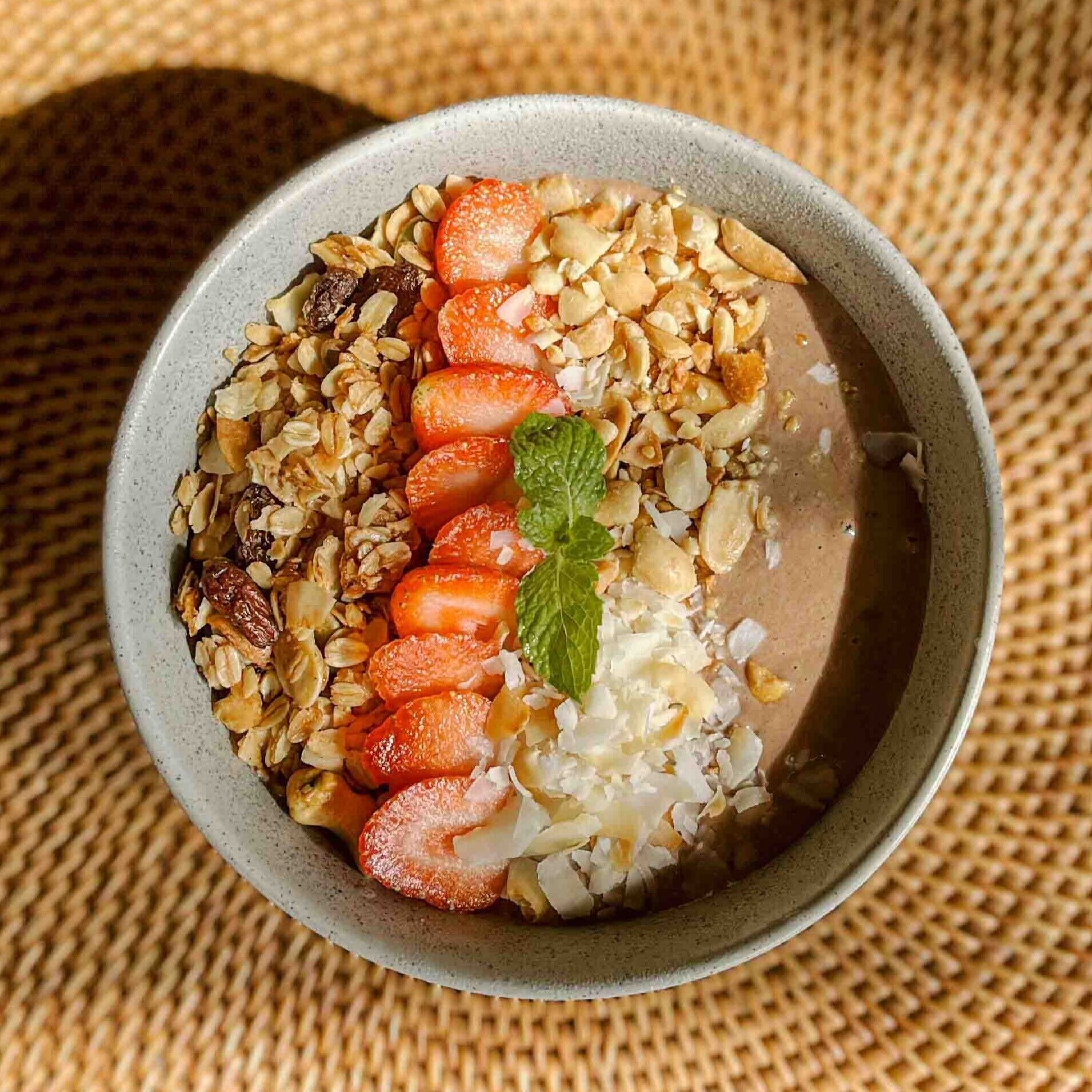 A bowl of oatmeal with strawberries and nuts.