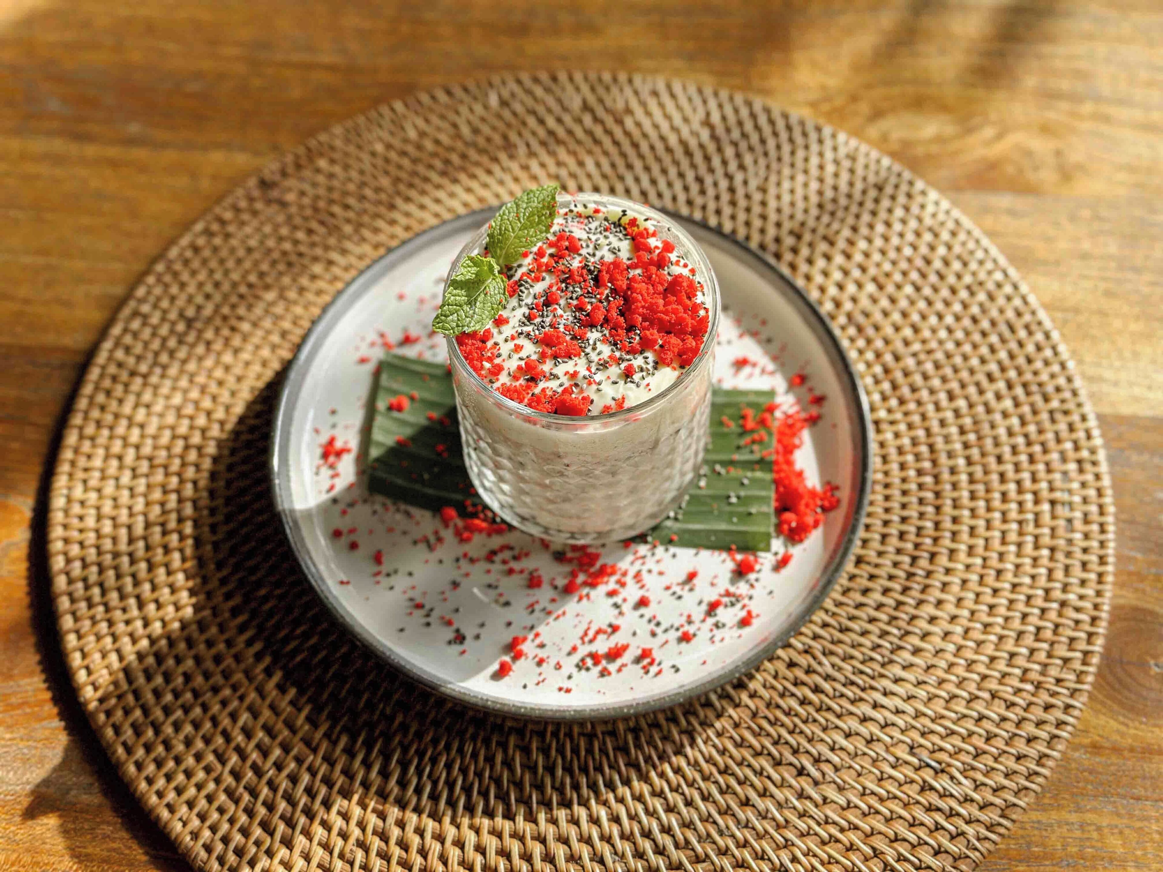 Un dessert présenté sur une assiette, accompagné d’un set de table en fibres tressées.