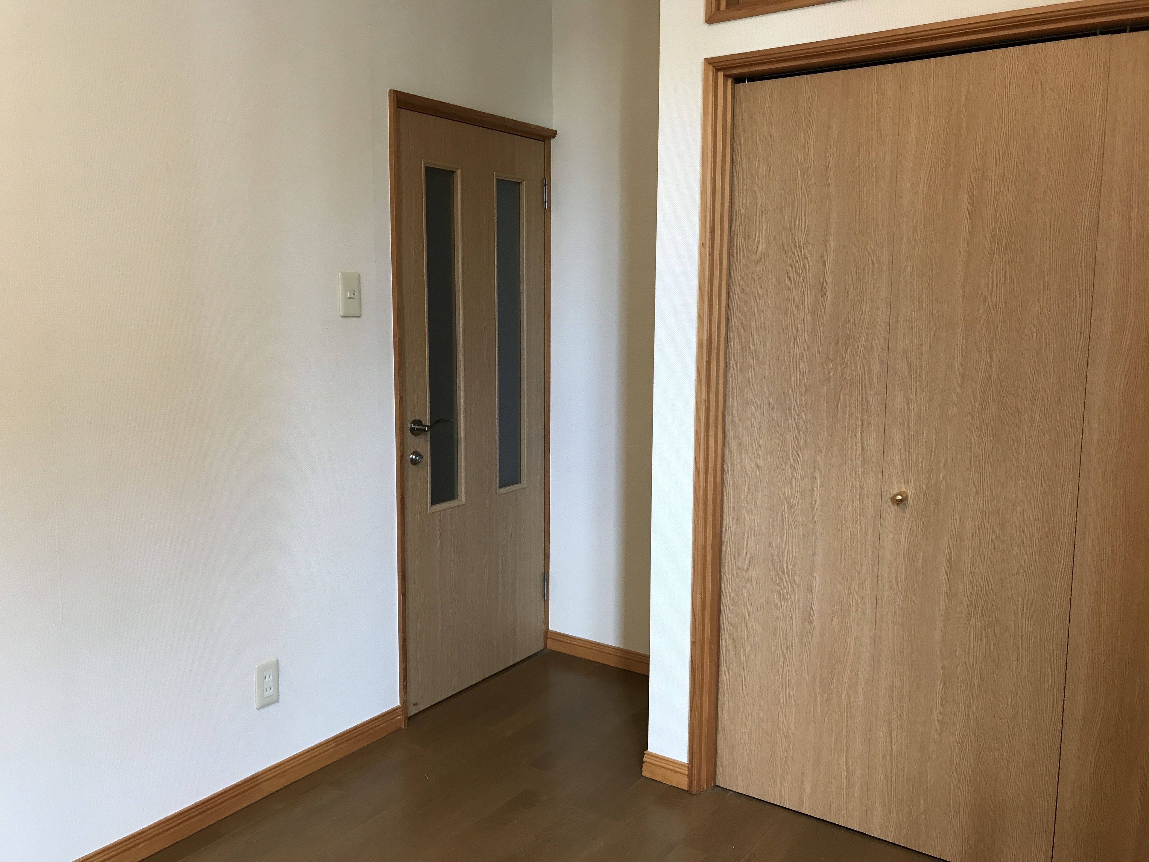 Ein Flur mit einer Holztür und einem großen Schrank.