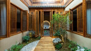 A traditional wooden building with a central courtyard, stone pathway, and wooden gates. - Huangshan Huanchun·Bingyu Resort (Huangshan)