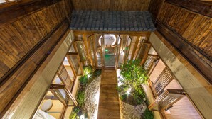 A wooden interior with a central staircase, wooden railings, and a view of the outside. - Huangshan Huanchun·Bingyu Resort (Huangshan)