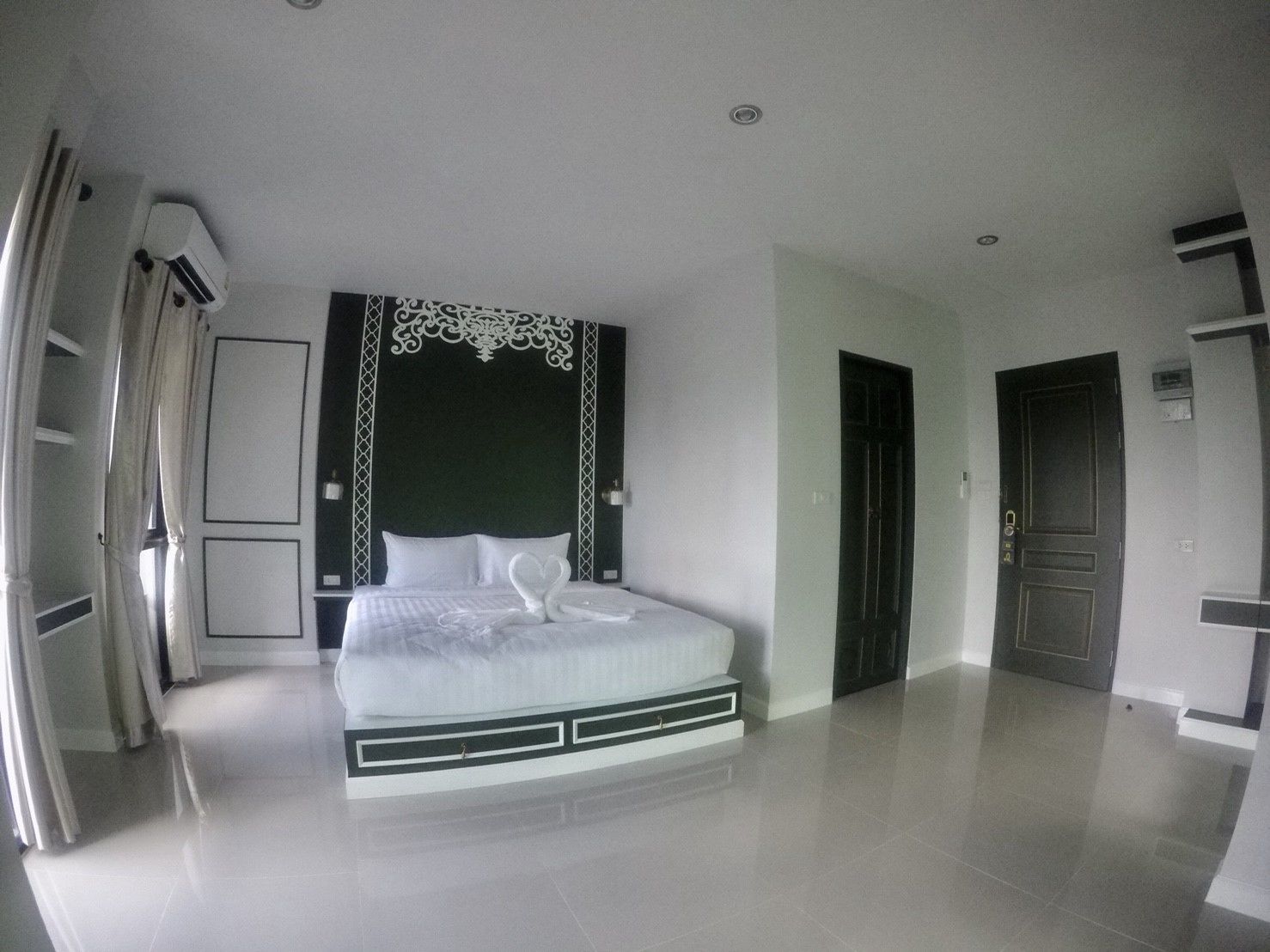 Een moderne hotelkamer met een groot bed, een kledingkast en een badkamer.