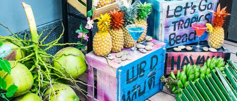 Une décoration sur le thème des tropiques, avec des ananas, des noix de coco et une pancarte sur laquelle on peut lire : « En route pour les plages tropicales ! »