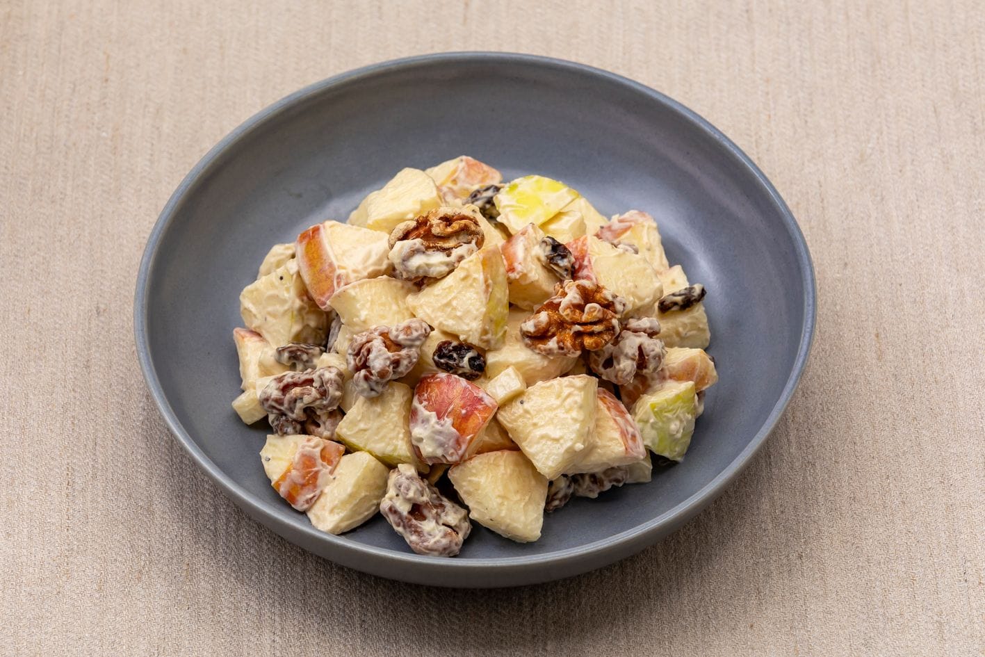 Een fruitsalade met noten op een structuurrijk oppervlak.