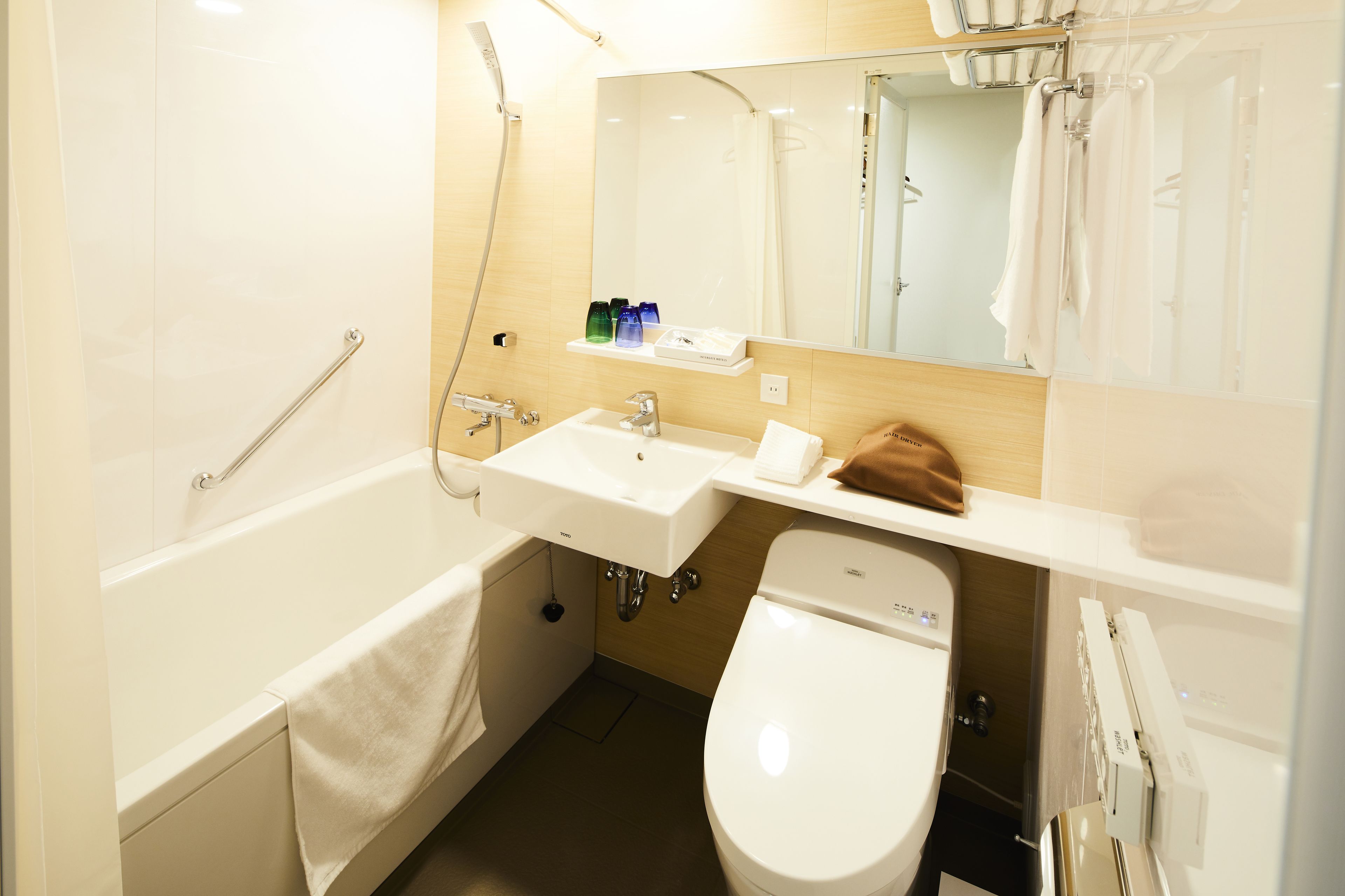 Une salle de bain moderne équipée d’une baignoire, de toilettes, d’un lavabo et d’un miroir au-dessus du lavabo.
