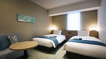 A hotel room with two beds, a sofa, a small table, and a wall map.