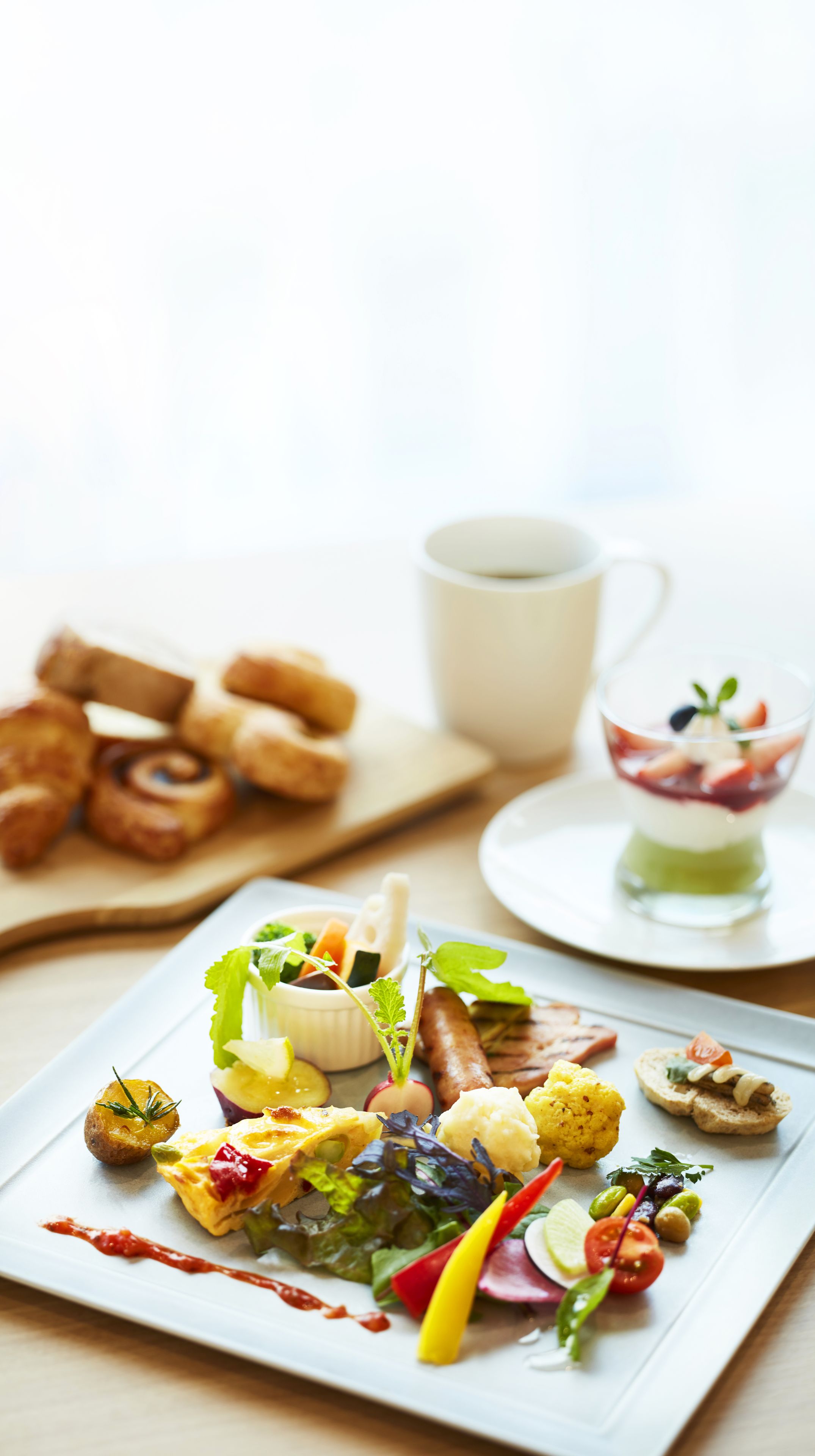 Una variedad de platillos en un plato blanco, que incluye una ensalada, un tazón pequeño de sopa y algunos pasteles.
