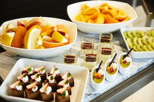 Verschiedene Desserts und Früchte auf einem Marmortisch.