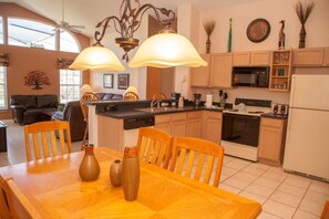Una cocina moderna con armarios de madera, una mesa de comedor con sillas y una isla central.