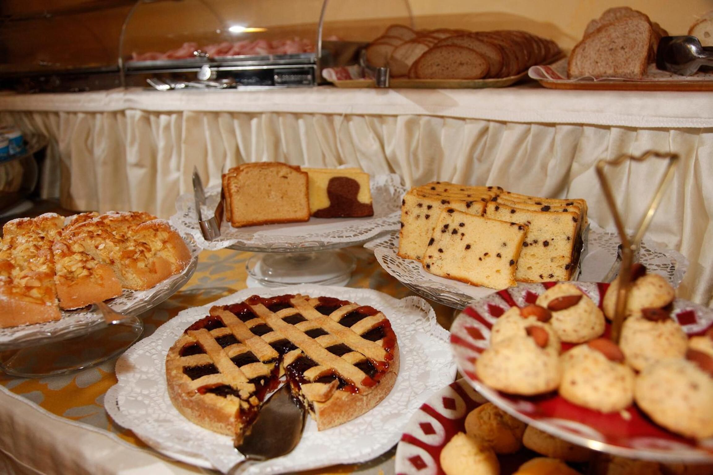 Een buffet met diverse gebakjes, waaronder taarten, cakes en gebak.