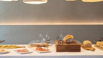 A buffet table with various food items and a wooden bread box.
