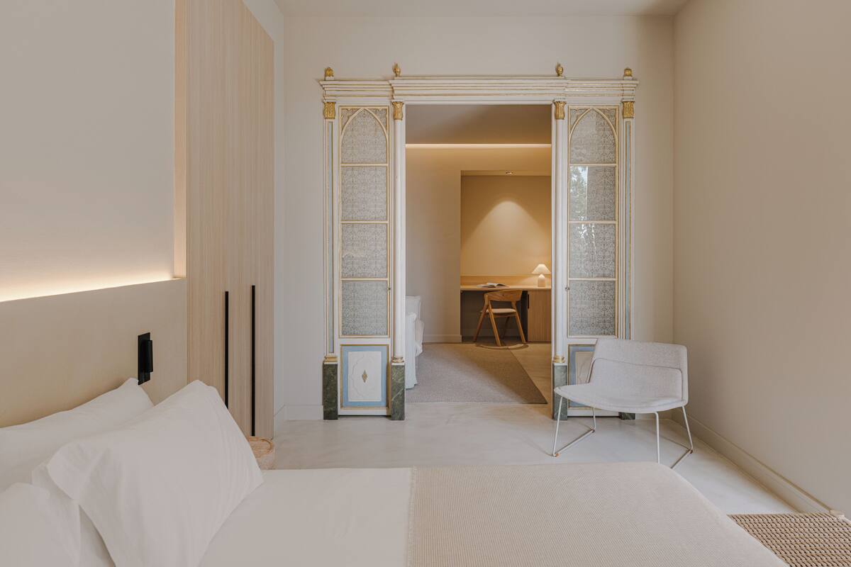 Une chambre moderne avec un grand lit, un bureau et une chaise.