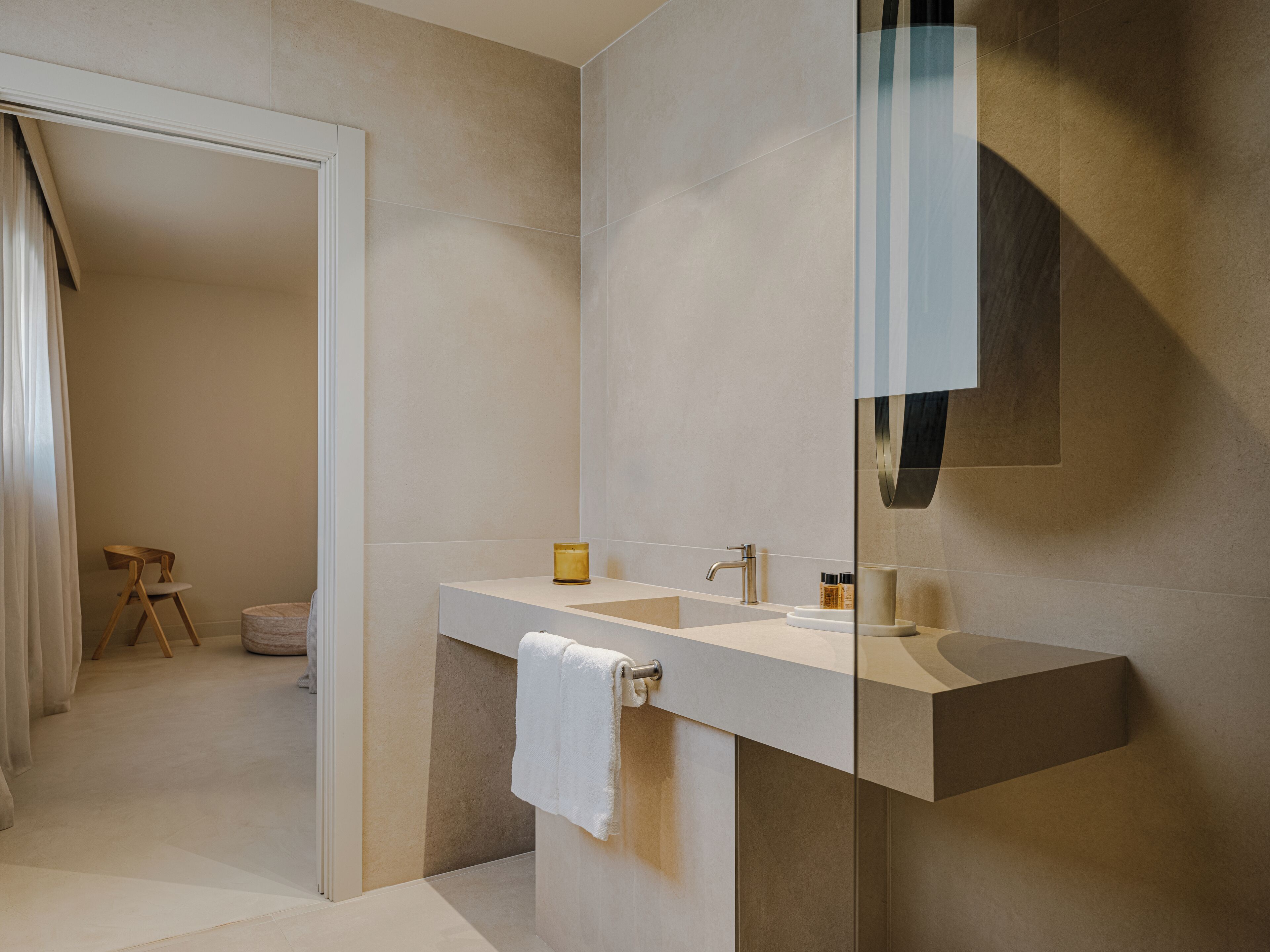 A modern bathroom with a large mirror, a sink, and a towel rack.