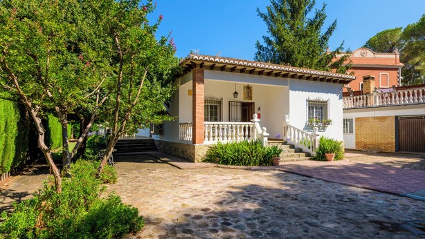A traditional house with a tiled roof, a balcony, and a stone-paved courtyard. - Casa San Rafael (Navajas)