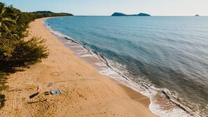 A beach with a clear view of the ocean, sandy shore, and distant islands. - Villa Beach Palm Cove (Clifton Beach)