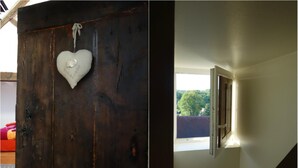 A wooden door with a heart-shaped ornament and a window with a view of trees. - Le Fassardy - Chambre d'Hôtes (Chateauroux)