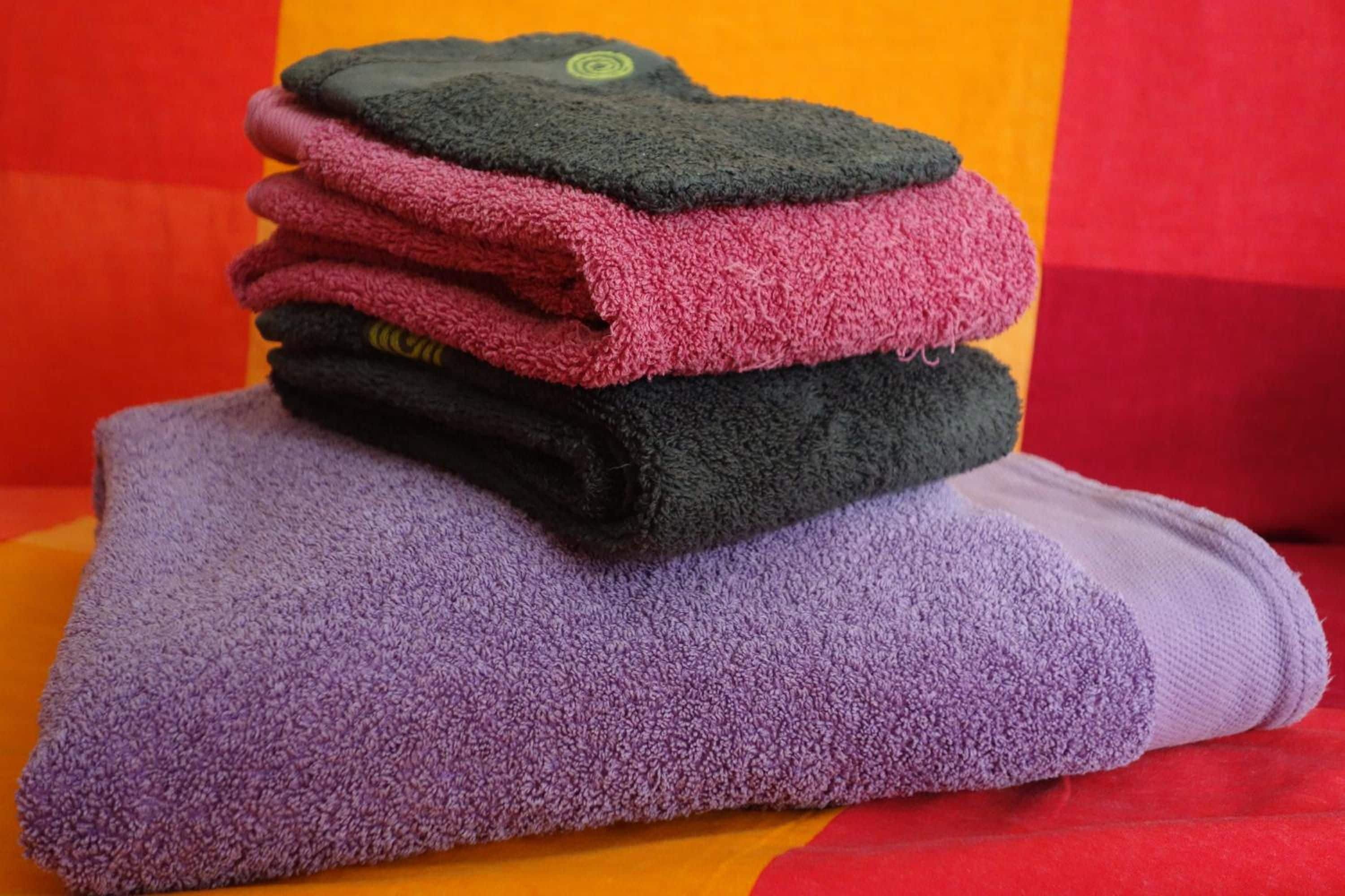 A stack of folded towels in various colors.