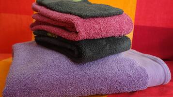 A stack of folded towels in various colors.