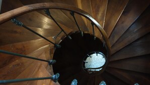 A wooden spiral staircase with metal handrails and a circular hole at the top. - Le Fassardy - Chambre d'Hôtes (Chateauroux)