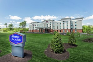 Edifício do Hampton Inn & Suites by Hilton com uma placa na frente.
