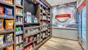 A snack aisle with various packaged snacks and a 'Welcome to Kitty' sign. - Hampton Inn & Suites Kittery-Portsmouth (Kittery)