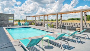 A pool area with lounge chairs and a pergola.