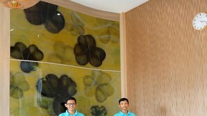 Una recepción de hotel con diseño moderno, un reloj en la pared y el logotipo de Capsule Hotel.