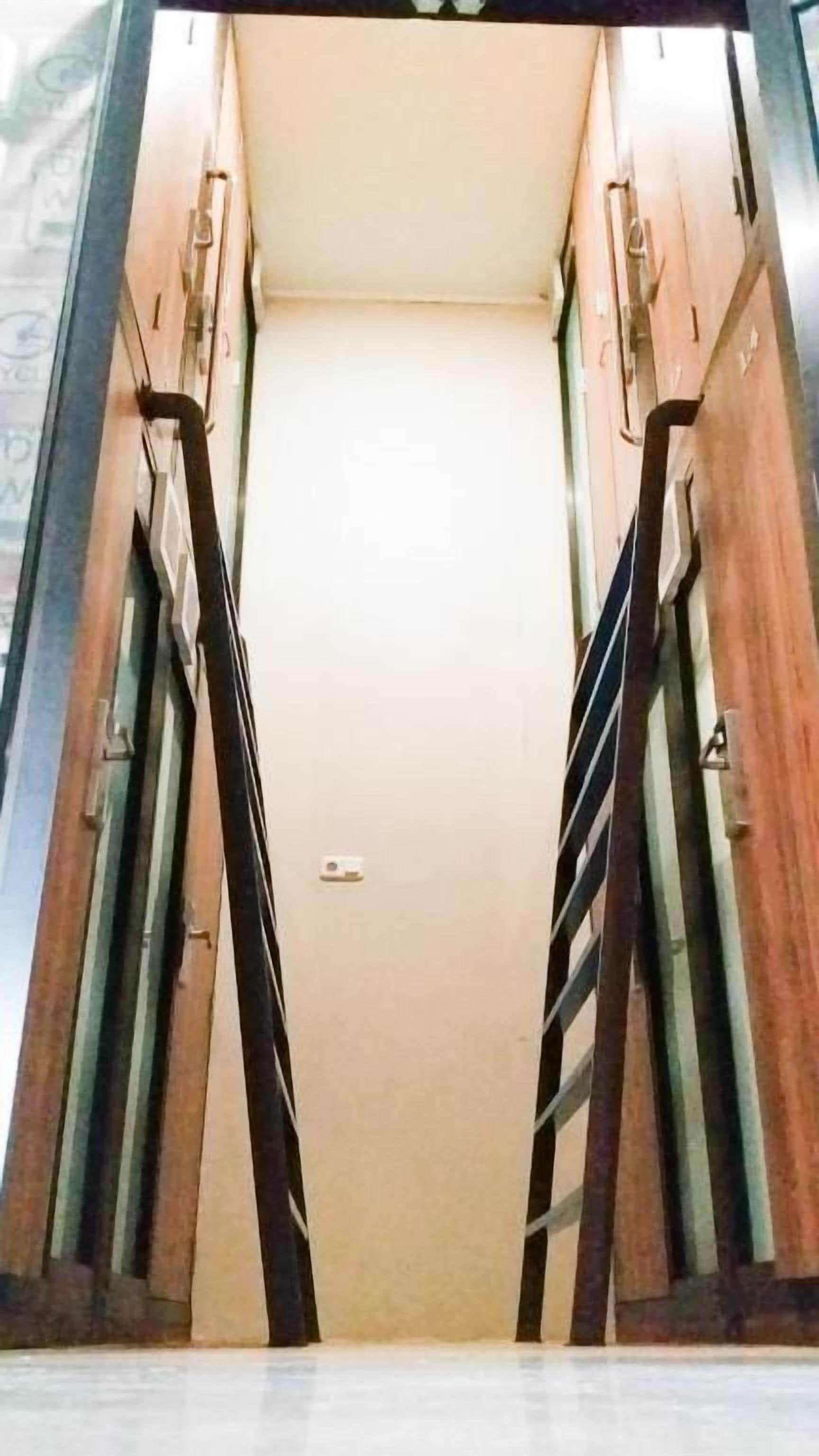 Corredor com moldura de porta de madeira e interruptor na parede.