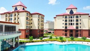 A hotel with a swimming pool, multiple buildings, and a well-maintained garden. - Rose Land Apartment Hotel (Naypyidaw)