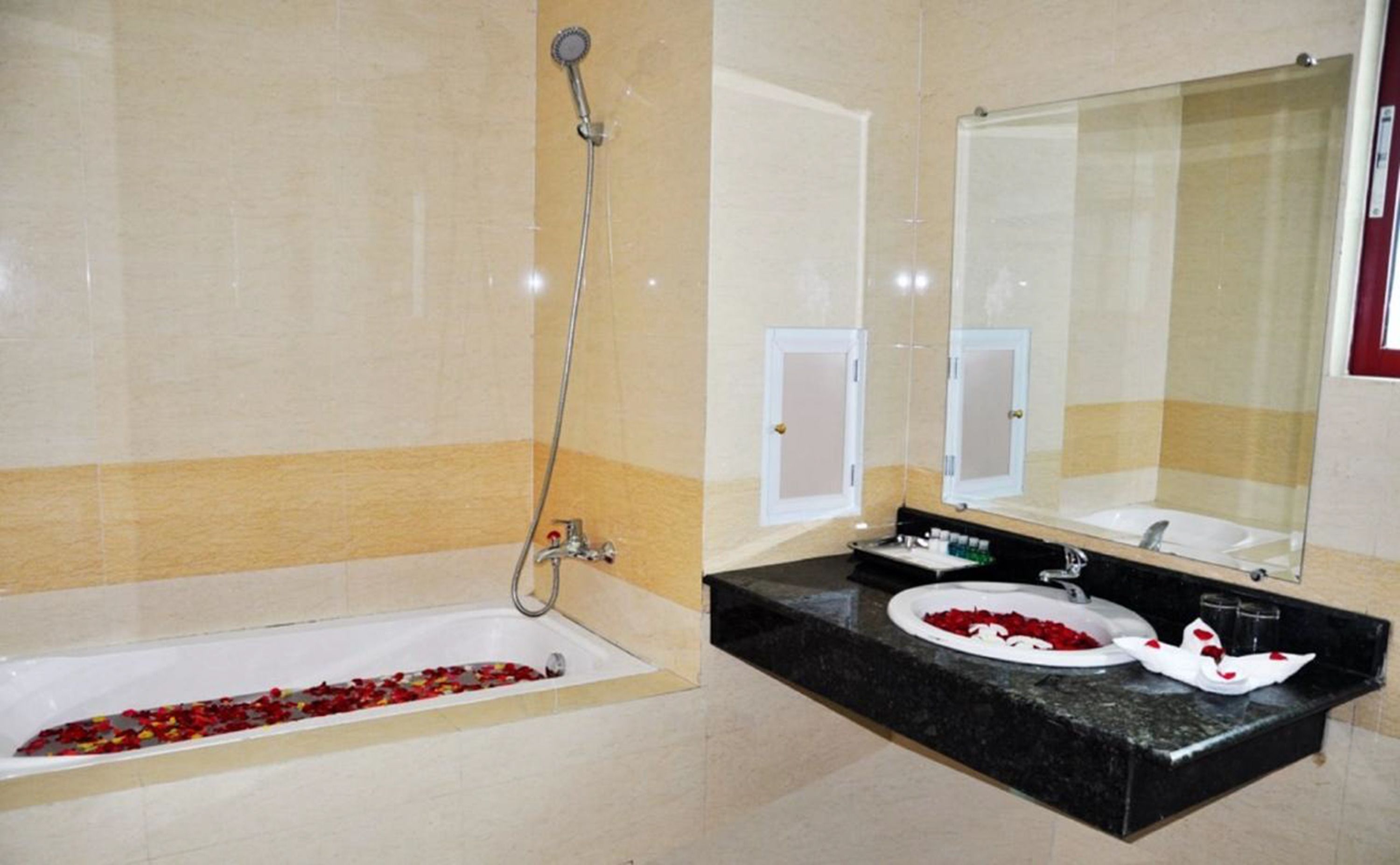 Un baño con bañera, ducha, lavamanos y espejo.