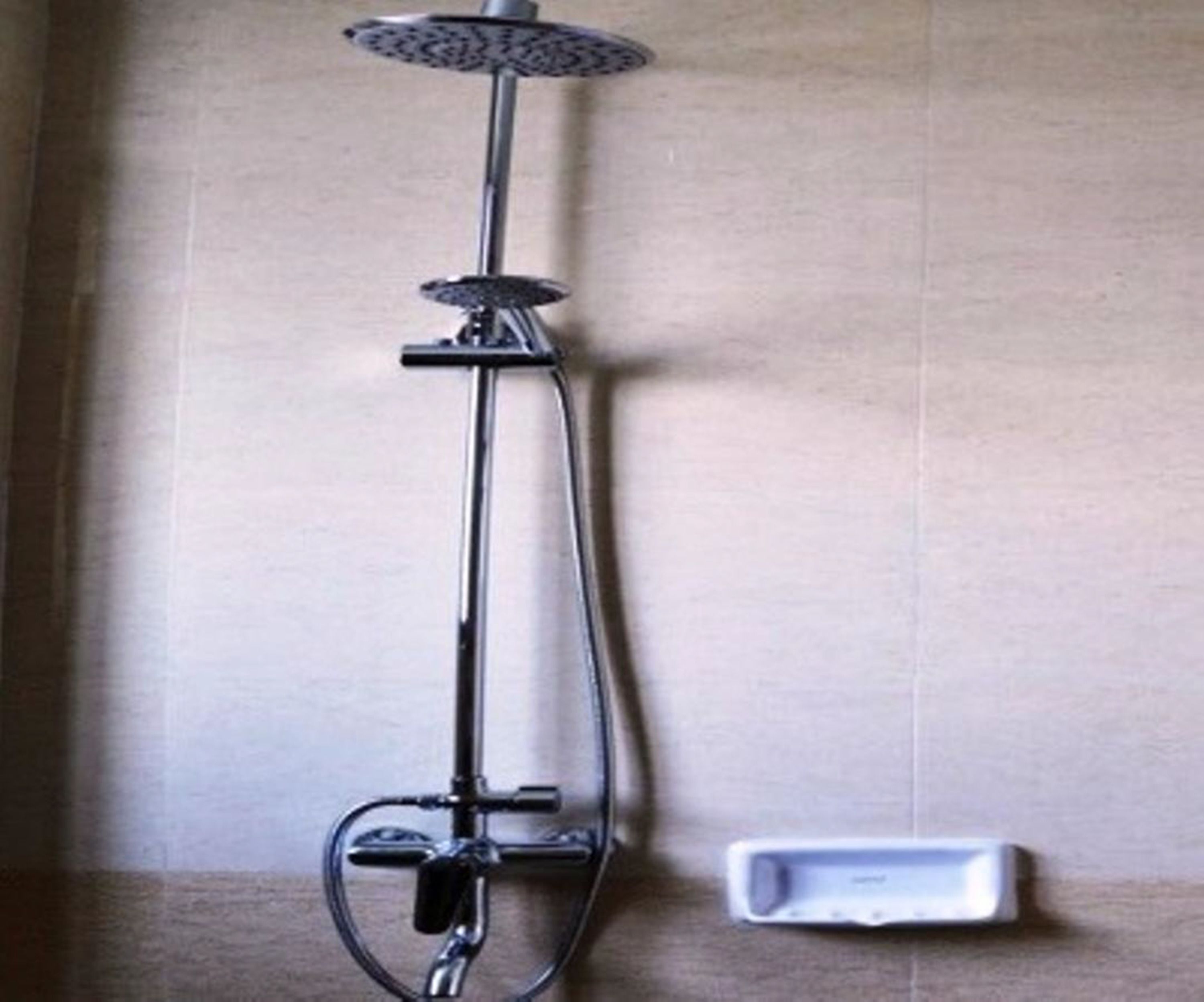 A shower with a handheld showerhead and a handheld control.