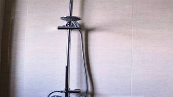 A shower with a handheld showerhead and a handheld control.