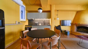 Een moderne keuken met een eethoek, een open haard en een televisie.