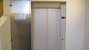 An elevator with a sign indicating floor assignments: Ground Floor, Lobby, First Floor, Offices, Second Floor, and Third Floor. - Churchill Apartments (York)