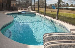 A swimming pool with a hot tub, a lounge chair, and a view of the surrounding landscape. - Ly53791 - Emerald Island - 6 Bed 5 Baths Villa (Kissimmee)