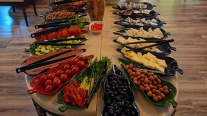 Una mesa de buffet con diversos alimentos y un florero en el centro.