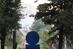 A silhouette of a head on a pedestal surrounded by trees. - La Casita Boutique Hotel for Lycian Way Hikers, Retreats, Solo Travellers, Long Stays, and Small Groups. (Kumluca)