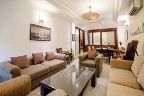 A living room with a sofa set, a coffee table, and a dining area with chairs and a table.
