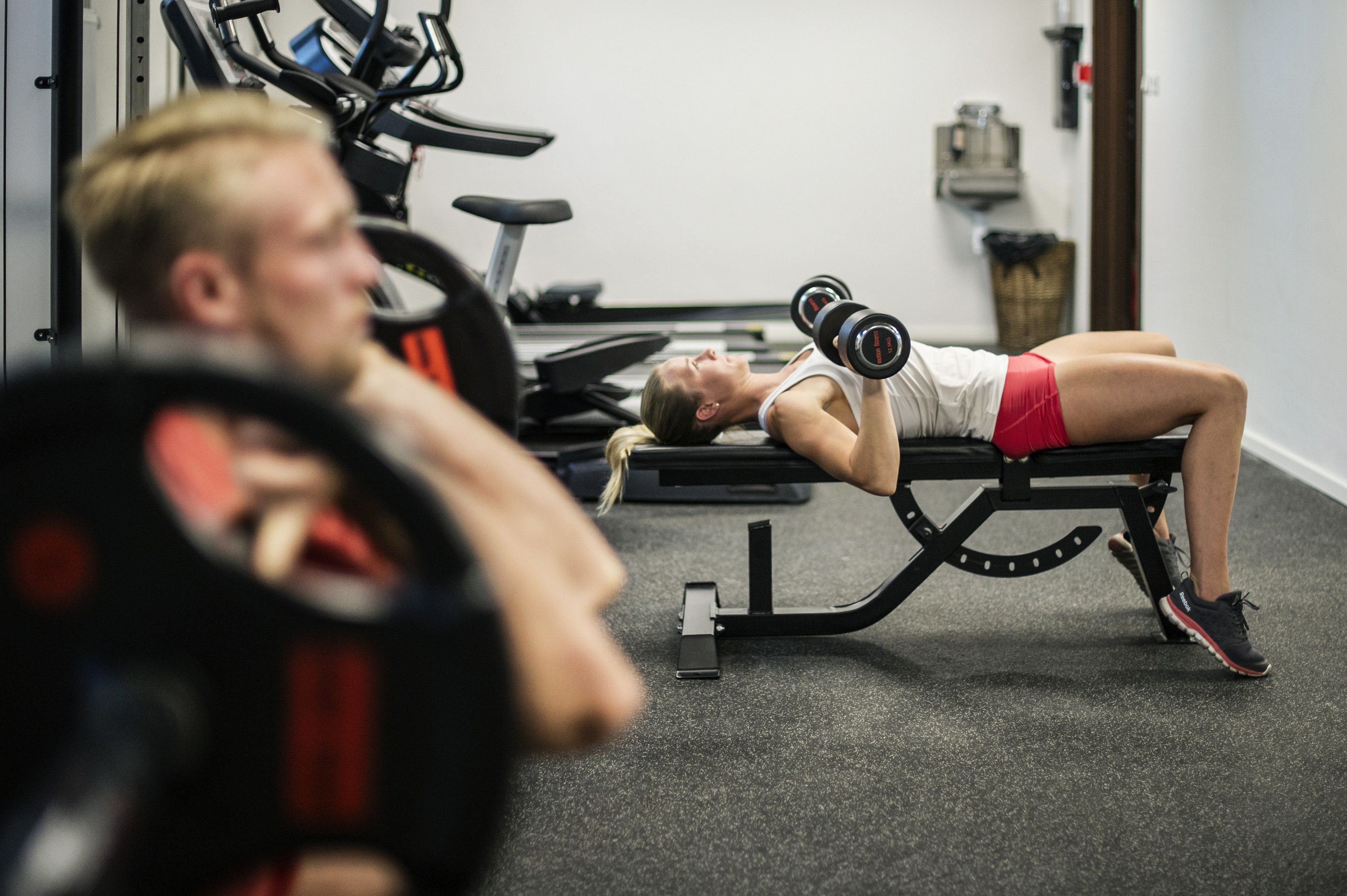 A gym with exercise equipment, including a bench and dumbbells.