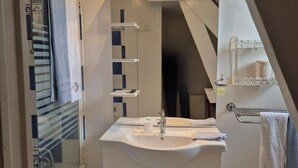 A modern bathroom with a glass shower enclosure, a white sink with a mirror above it, and a towel rack. - Villa des Iris (Saint-Felix)