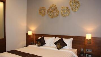 A hotel room with a large bed, two bedside lamps, and decorative wall art.