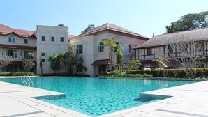 Una piscina rodeada de edificios con un bordeado de baldosas.