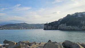 A coastal landscape with rocky outcrops and a distant town. - 100 Passi Dal Mare (Agropoli)